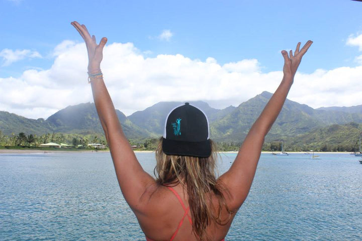 Black Flexfit Adjustable Hat with White Mesh back with Paddle Board Girl and Dog silhouette embroidered in Seafoam green.