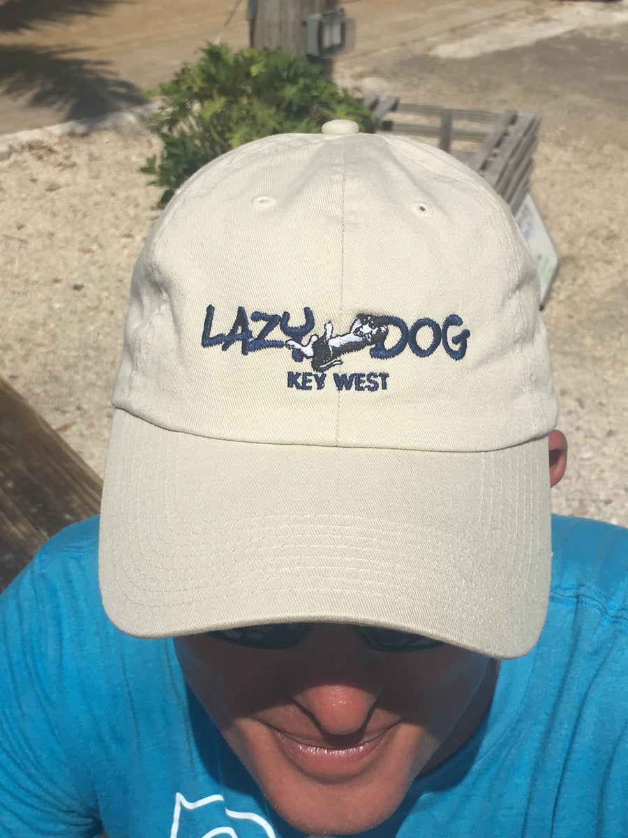 Lazy Dog Brand All Cotton, Adjustable Ball cap with navy lettering "Lazy Dog" and a lounging black and white border collie embroidered in center of hat. Natural